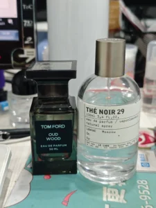 Flacon de parfum inspiré posé à côté d'une fragrance de luxe de type Another 13, illustrant la différence de packaging et de prix.