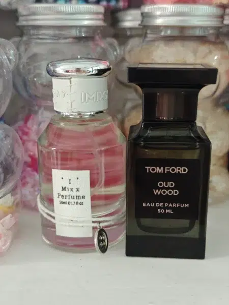 Comparatif visuel entre le flacon original Tom Ford Oud Wood et une alternative de parfum boisé longue tenue