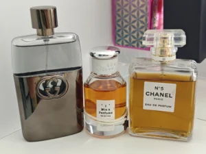 Décoder l'Industrie du Parfum : Les Secrets de la Pyramide Olfactive et le Meilleur Dupe Chanel N°5 2 Flacon d'eau de toilette aux notes aldéhydées à côté d'un parfum de créateur, illustrant les équivalents de parfums floraux.