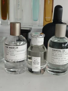 Flacon de parfum de luxe type Santal 33 face à son équivalent longue tenue de fabrication française Imixx.