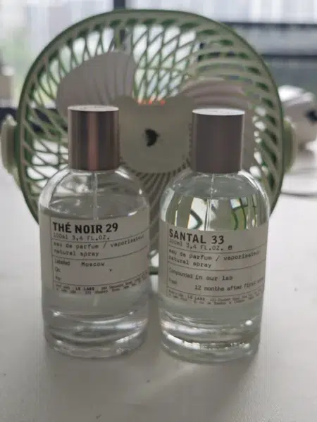 Comparaison visuelle entre un flacon de parfum de luxe ozonique et une alternative dupe Baie 19 concentrée en extrait.