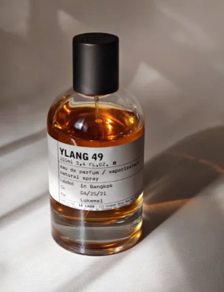 Comparatif visuel entre le parfum de luxe Le Labo Ylang 49 et une alternative de laboratoire en Extrait de Parfum 28% sur fond de matières premières botaniques
