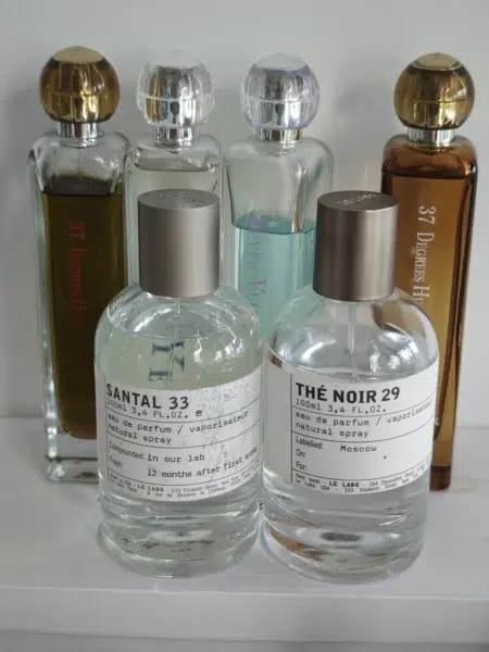 Comparaison de prix et de packaging entre un parfum de luxe de type Santal 33 à 300 euros et une alternative artisanale française de qualité laboratoire.