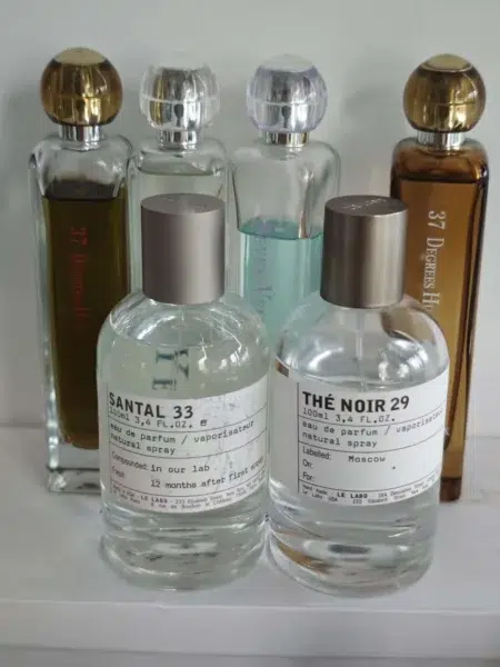 Comparaison visuelle entre un flacon de parfum de niche traditionnel et son alternative abordable proposée par la marque Imixx Perfume.