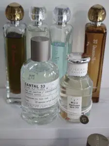 Différence de couleur et de macération entre un parfum boisé du marché gris Costco altéré par le temps et une formulation Eau de Parfum fraîchement assemblée.